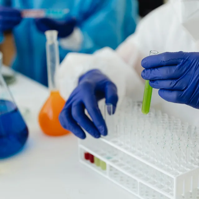 Researchers in a laboratory handling test tubes and flasks